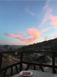 a plate of pizza on a wooden table at sunset