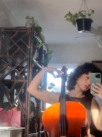 a woman taking a selfie with a cello