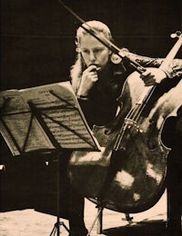 an old photo of a man playing a cello